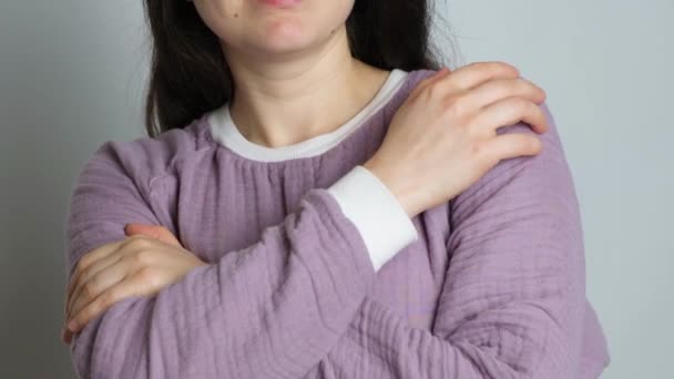 一位穿着紫色温暖的麝香睡衣的黑发女人拥抱着自己 享受着睡衣的舒适感 — 图库视频影像