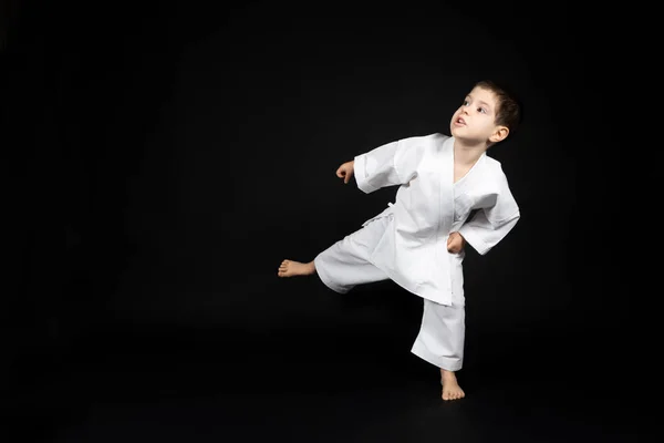 Niño Pequeño Kimono Practica Karate Sobre Fondo Negro Pateando Hacia — Foto de Stock