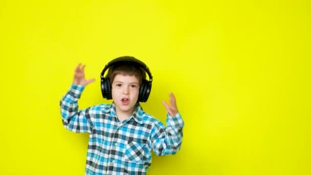 Šťastný Chlapec Bezdrátových Sluchátkách Poskakuje Usmívá Žlutém Pozadí — Stock video