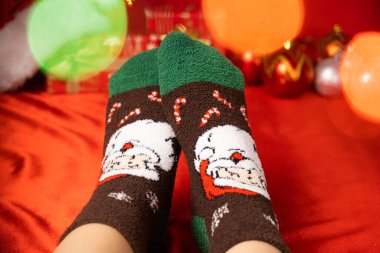 Noel Baba 'nın yakın planında kadın ayakları ve sıcak Noel çorapları..