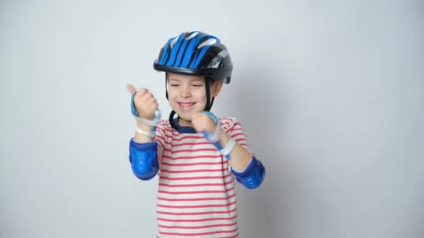 幸せな赤ちゃんの親指を 保護ヘルメット 肘パッドと手袋を身に着けている — ストック動画