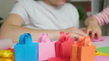 Anne ve oğlu kağıttan, origamiden, hayvan figürleri yaratıyorlar.