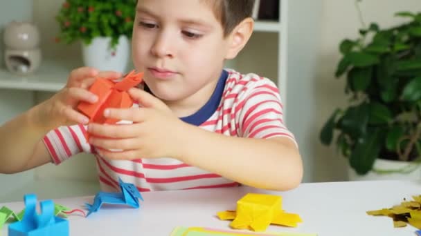 Een Jongetje Speelt Met Octopus Beeldjes Gemaakt Van Origami Papier — Stockvideo