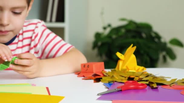 折り紙の人形で遊ぶ少年 紙のヘビとタコ — ストック動画