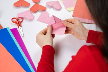 Sevgililer Günü için origami kalbi yapıyorum. Kendi ellerinle kağıttan yapılmış el işleri.