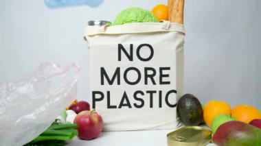Plastik torbalar tekrar kullanılabilir kumaş bir alışveriş çantasının üzerine düşer..