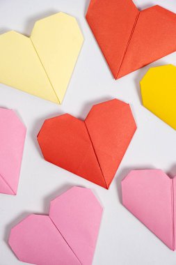 Sevgililer Günü için Origami - beyaz arkaplanda kağıttan yapılmış kalpler kendin yap..