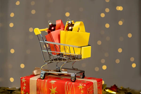 Shopping cart with packages, purchases, discounts and gifts for Christmas and New Year.