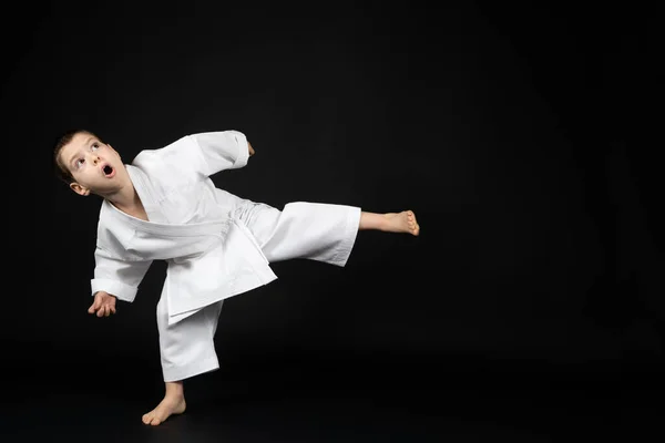 Little Boy Kimono Practices Karate Black Background Kicking Forward — Stock Photo, Image