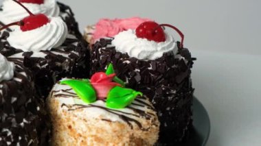 Çiçek şeklinde vişneli ve kremalı kekler, yan plan yakın plan..