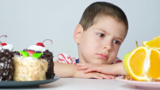 Mały Chłopiec Wybiera Jeść Ciasto Czy Owoce — Wideo stockowe