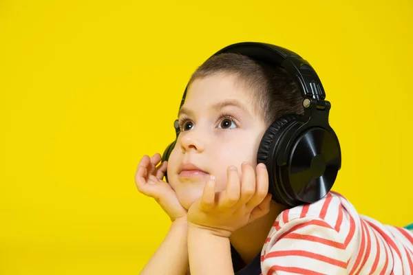 Cute Letni Chłopiec Bezprzewodowych Dużych Słuchawek Leży Żółtym Tle Podpierając — Zdjęcie stockowe