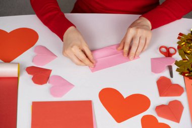 Sevgililer Günü için origami kalbi yapıyorum. Kendi ellerinle kağıttan yapılmış el işleri.