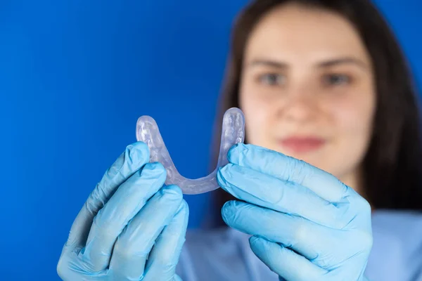 Diş koruyucusu tutan doktor, çene kaslarını gevşetmek için temporomandibular eklemlerin işlev bozukluğu, bruksizm ve maloksiyonun tedavisi için atel.