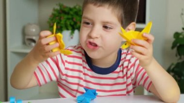 Küçük bir çocuk origami kağıdından yapılmış ahtapot figürleriyle oynuyor.