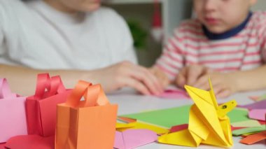 Anne ve oğlu kağıttan, origamiden, hayvan figürleri yaratıyorlar.