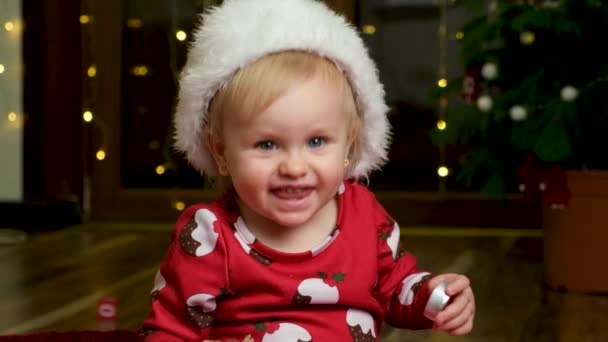 Roczna Piękna Dziewczyna Świątecznych Ciuchach Zdejmuje Kapelusz Świętego Mikołaja Uśmiecha — Wideo stockowe