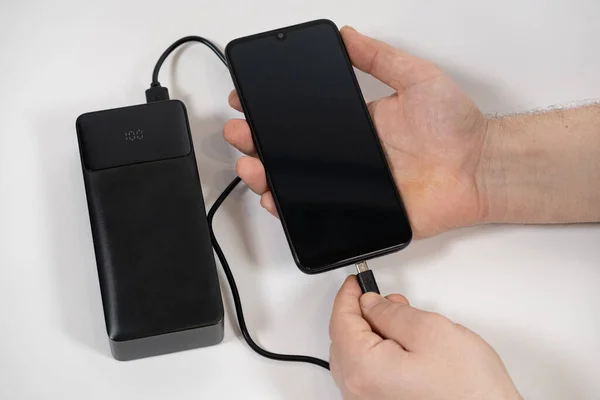 Connecting a mobile phone to a power bank. Charging gadgets from power banks