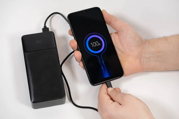 Connecting a mobile phone to a power bank. Charging gadgets from power banks