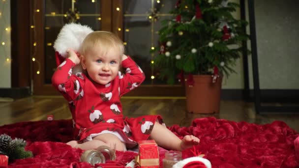 Όμορφο Κοριτσάκι Ενός Έτους Ξανθά Μαλλιά Που Παίζει Χριστουγεννιάτικο Καπέλο — Αρχείο Βίντεο
