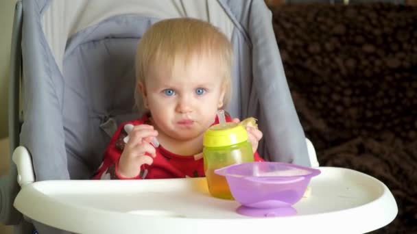 Liten Ettårig Flicka Äter Banan Sittandes Barnstol — Stockvideo
