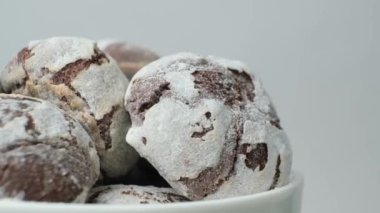 Chocolate chip cookies with cocoa and powdered sugar on a plate on a white background