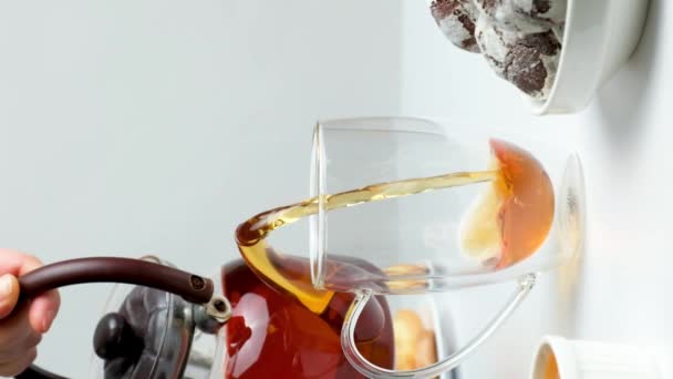 茶壶里的红茶倒入一个杯子里 杯子的底部是双层的 背景是白色的 茶道仪式 — 图库视频影像