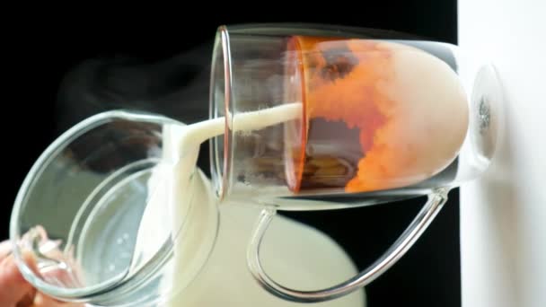 ミルクティーを作る ガラス瓶からミルクを黒英語の紅茶に注ぎます — ストック動画