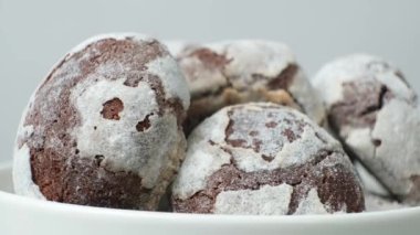 Chocolate chip cookies with cocoa and powdered sugar on a plate on a white background
