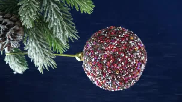 圣诞和新年前夕 一串串的雪落在一棵蓝色背景的圣诞树上的粉色球上 — 图库视频影像