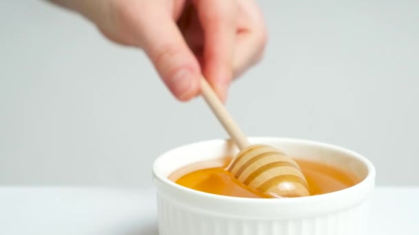 Woman Shows Liquid Linden Honey Ceramic White Bowl Mixes Honey — Stock Video