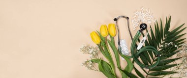 Bouquet of flowers and stethoscope on a beige background, a place for text, happy doctors day, nurses week and other medical holidays