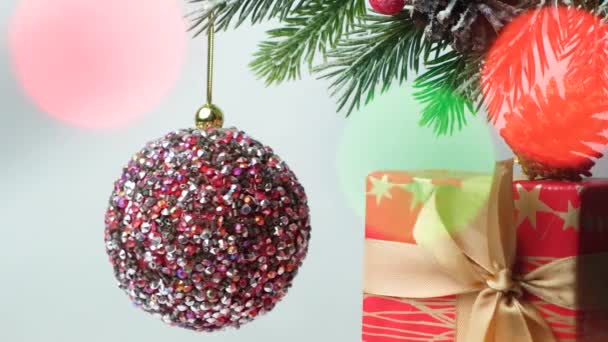 Shiny Pink Ball Spins Snow Covered Christmas Tree Bokeh Garland — Vídeo de Stock