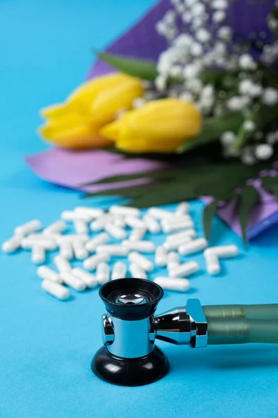 Happy doctors or nurses day, medical holiday, card with flowers, pills and stethoscope