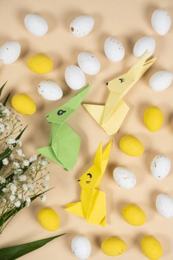 Mutlu Paskalyalar - origami kağıdından tavşanlar, yumurtalar ve çiçekler, üst manzara.