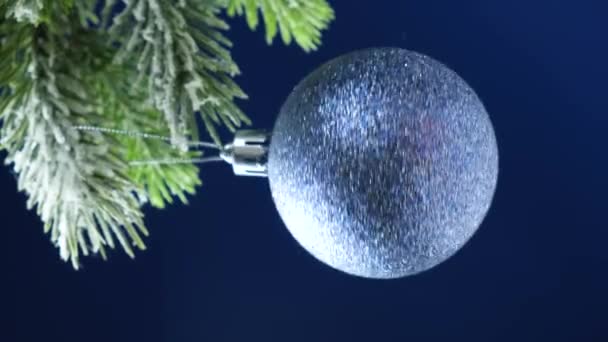 Shiny Blue Ball Spins Snow Covered Christmas Tree Vertical Video — Vídeos de Stock