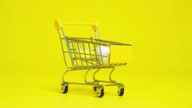 Easter Sale - Yellow and White Painted Eggs Fall Into The Shopping Cart.
