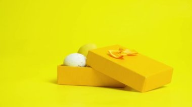 Easter sale and shopping - eggs are poured into a yellow gift box