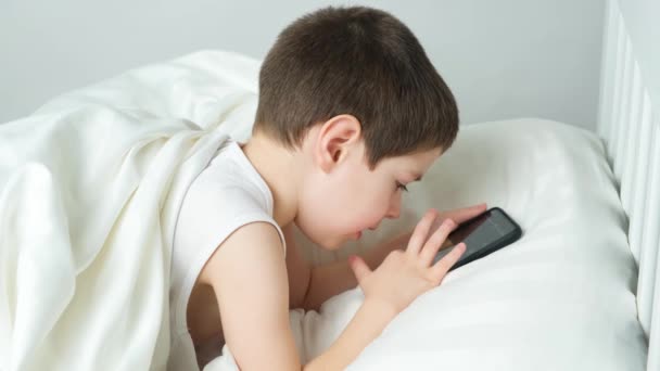 Pięciolatek Bawi Się Telefonem Leżąc Łóżku Gadżety Łóżku Przed Snem — Wideo stockowe