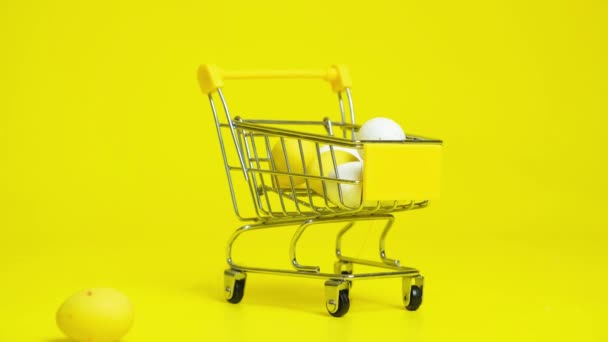 复活节特价 黄色和白色彩绘的鸡蛋掉进购物车 — 图库视频影像
