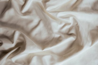 Abstract beige fabric background, satin stripe texture, wavy folds of elegant expensive fabric.