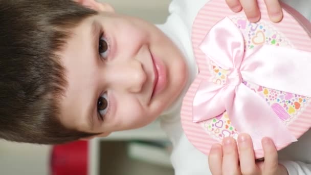 Cute Little Preschool Brunette Boy Holds Box Shape Pink Heart — Stock videók