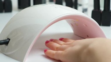Drying the top for gel polish in an ultraviolet LED lamp. Manicure at home yourself, beauty salon.