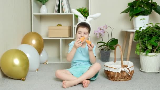 Egy Óvodás Húsvéti Fiú Répával Játszik Nyúl Fülekkel Fején — Stock videók