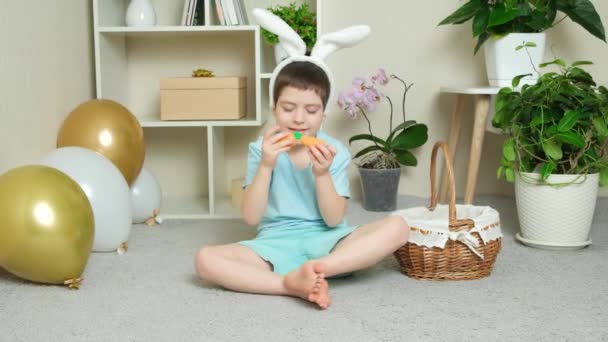 Velikonoční Kluk Hraje Mrkví Králičíma Ušima Hlavě — Stock video