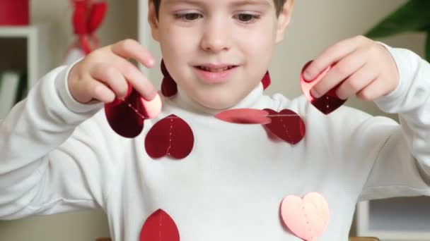 Niedliche Kleine Vorschulkind Spielt Mit Einer Girlande Form Von Herzen — Stockvideo