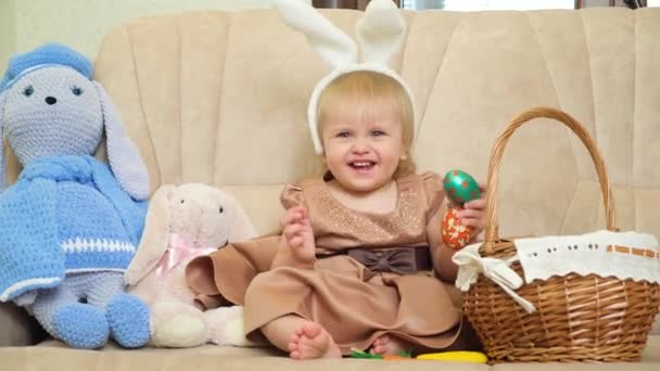 Wielkanocne Dziecko Mała Blondynka Króliczymi Uszami Głowie Bawiąca Się Malowanymi — Wideo stockowe