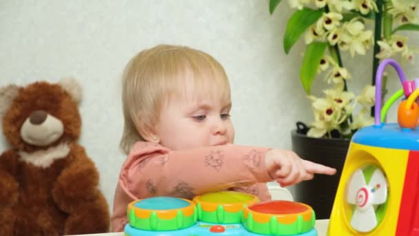 Bir Buçuk Yaşındaki Bir Kız Oyuncaklarla Oynarken Parmaklarını Emer — Stok video