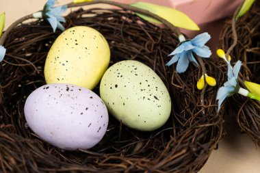 Bej bir arka planda hasır yuva sepetlerinde paskalya yumurtaları