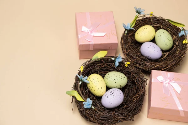 Gifts for Easter, Easter sale. Eggs in nests and gift boxes on a beige background